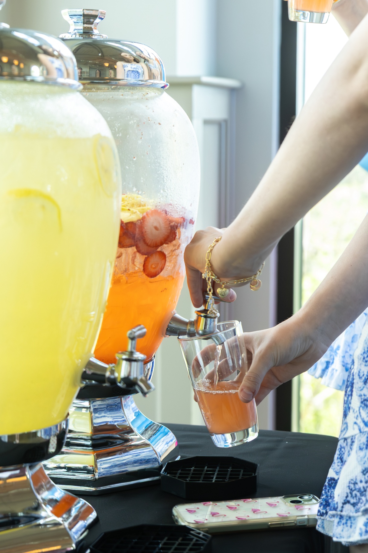 Pouring pink lemonade at a beverage station.