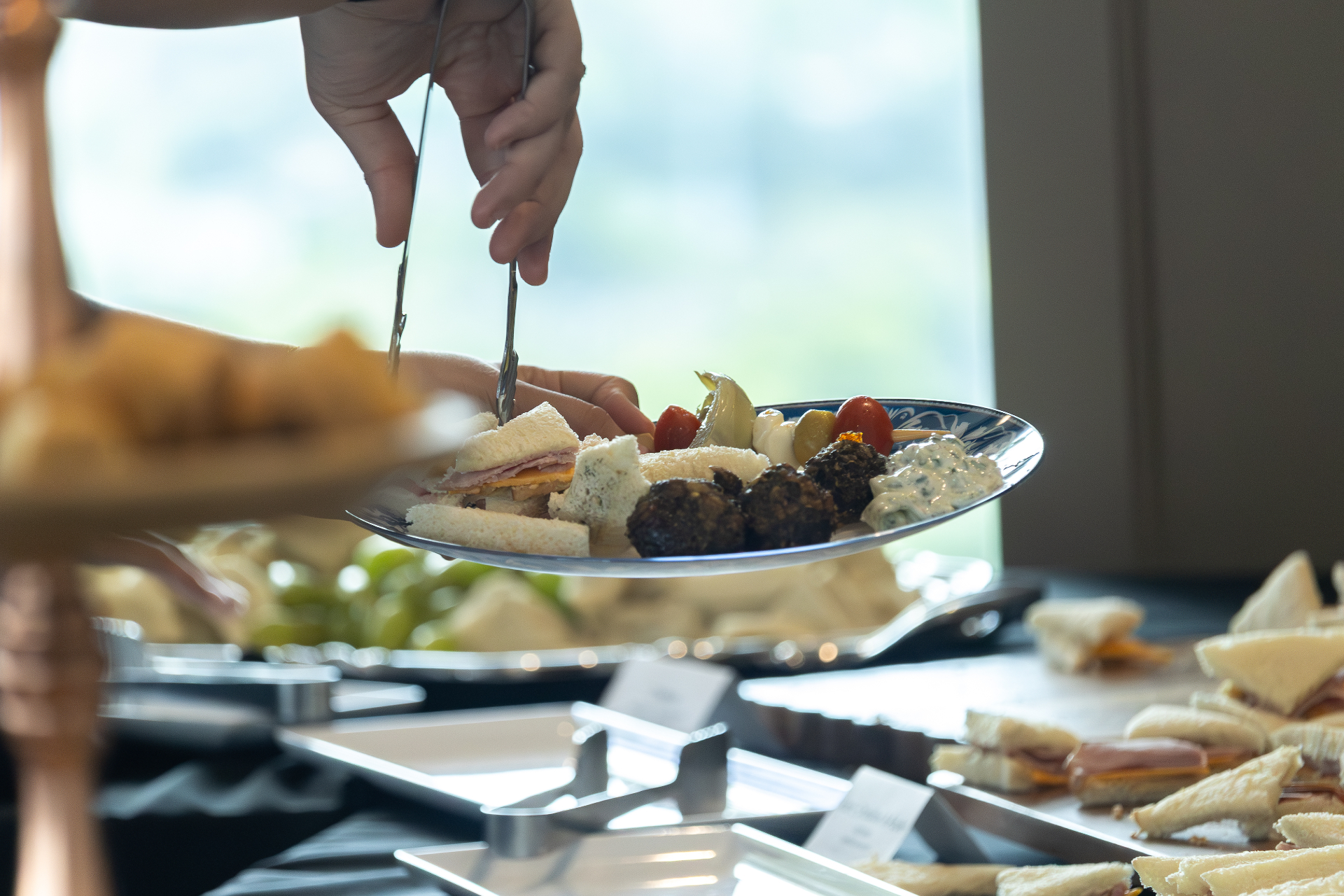 Plate being filled with Mediterranean appetizers.