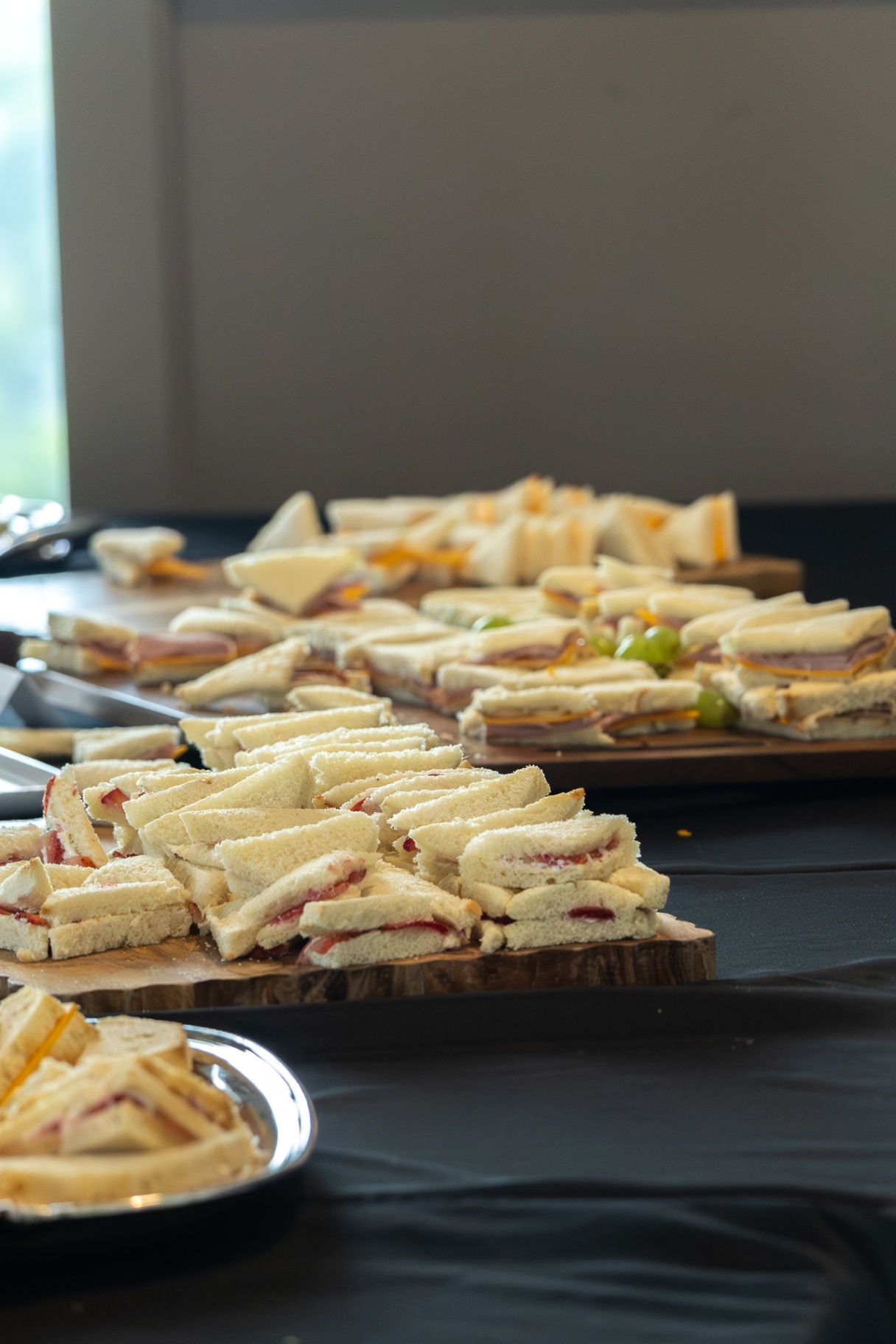 Platter of small triangle sandwiches on a catering table.