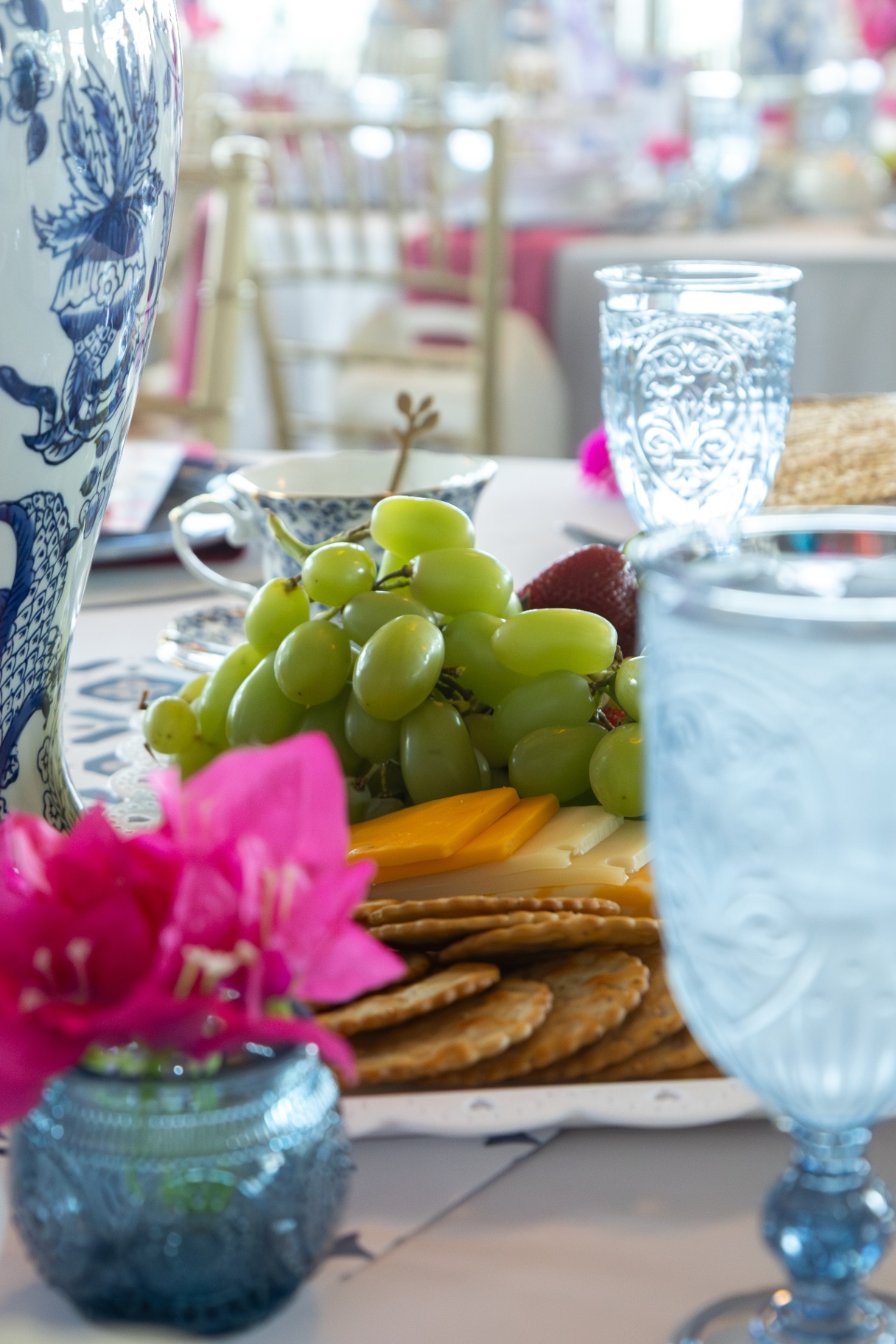 Low-angle detail of fruit, cheese, and crackers on an event table.